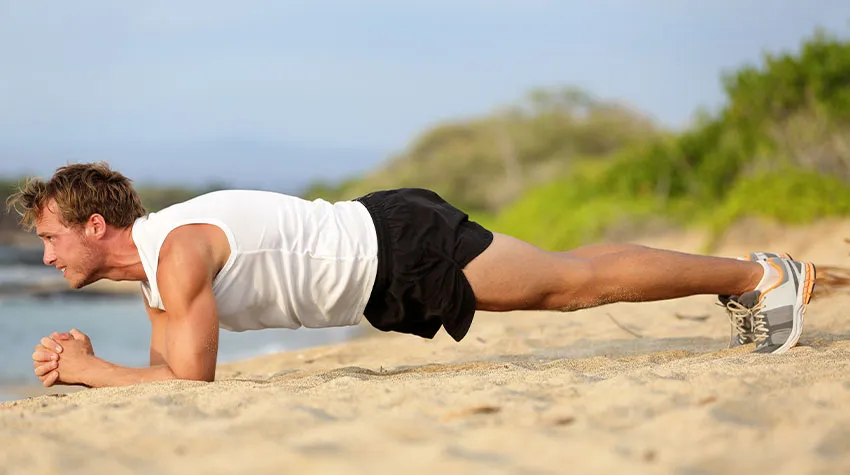 Mann führt Planks am Ostseestrand von Ahrenshoop durch. ©Adobe Stock, Maridav