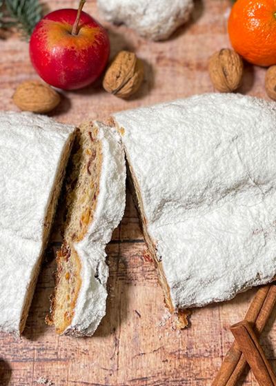 Ein aufgeschnittener Stollen liegt auf einem weihnachtlich dekorierten Tisch.