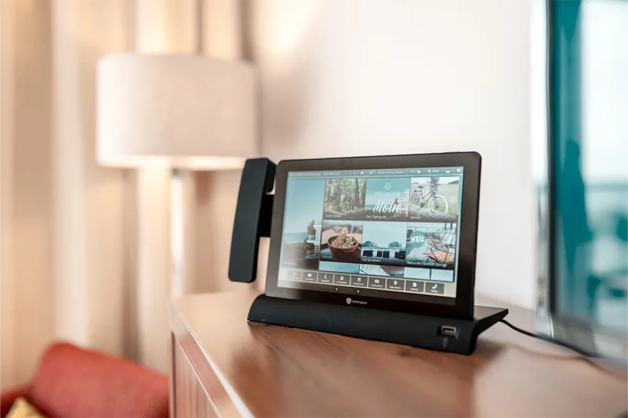 Digitales Infotablet auf einem Sideboard im Zimmer des THE GRAND Ahrenshoop.