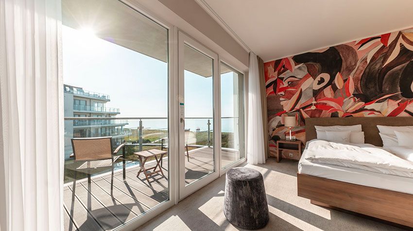 Helles Zimmer mit Balkon und Blick aufs Meer in moderner Unterkunft an der Ostsee.