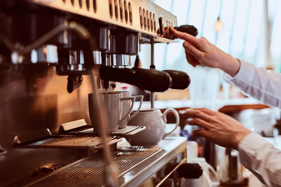 Servicekraft bedient professionelle Kaffeemaschine im THE GRAND Ahrenshoop