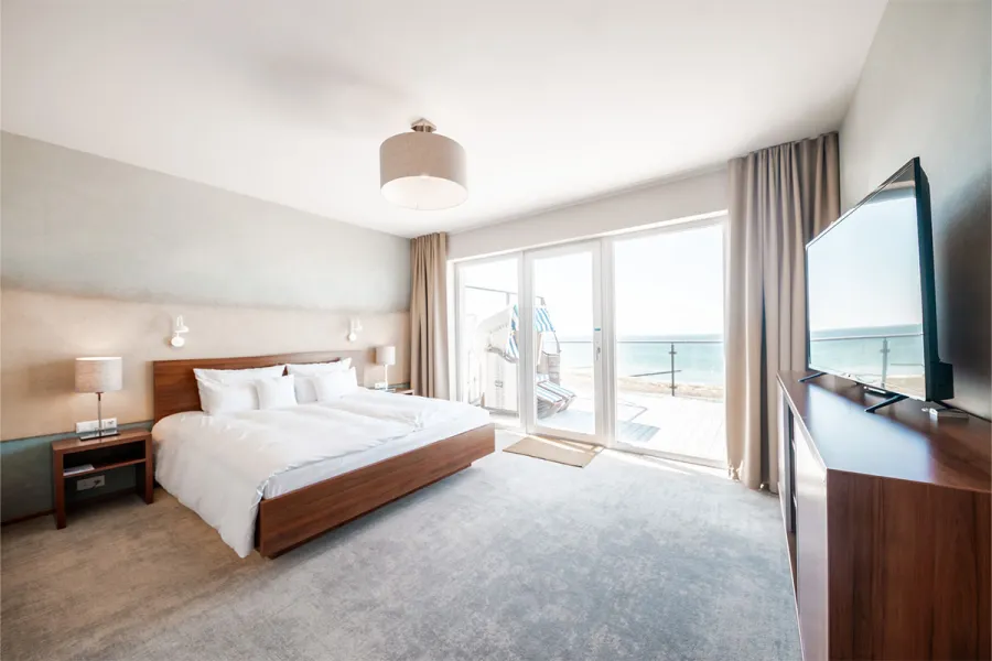 Helles Hotelzimmer mit Doppelbett, Balkon und Meerblick im THE GRAND Ahrenshoop.