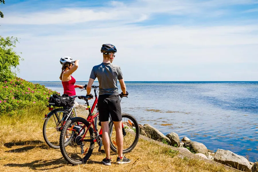 Radfahrer machen Pause an der Küste nahe THE GRAND Ahrenshoop mit Blick auf die Ostsee