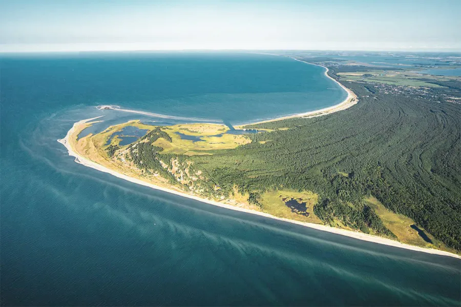 Luftaufnahme der Küstenlandschaft an der Ostsee bei Ahrenshoop mit Meer und Wald.
