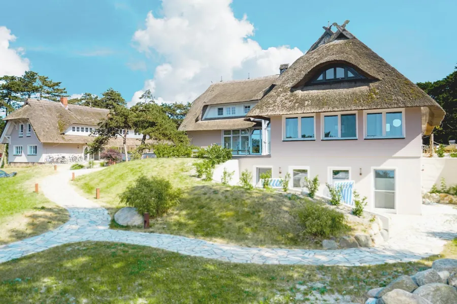 Reetgedeckte Häuseranlage mit Garten und Wegen im Partnerhotel STRANDHAUS Ahrenshoop.