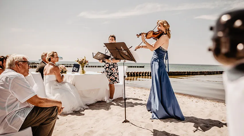 Eine Hochzeit am Strand, die mit Musik untermalt wird: Besser geht es nicht. © Fotostudio am Haff