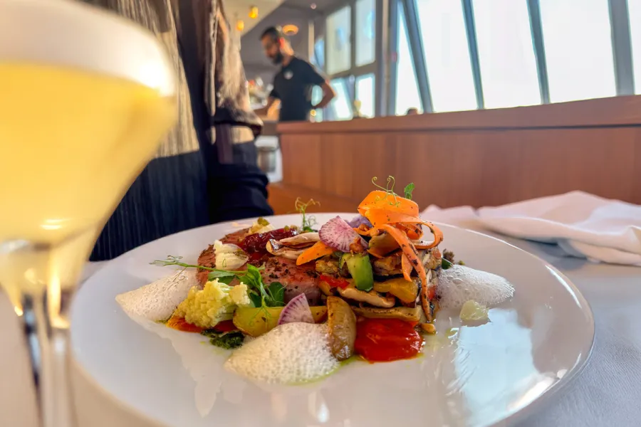 Kreativ angerichtetes Gourmetgericht mit frischem Gemüse und Cocktail im WEITBLICK im THE GRAND Ahrenshoop
