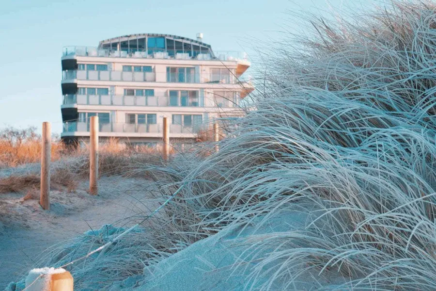 Hotelgebäude des THE GRAND Ahrenshoop hinter Dünen mit Strandhafer in Ahrenshoop.