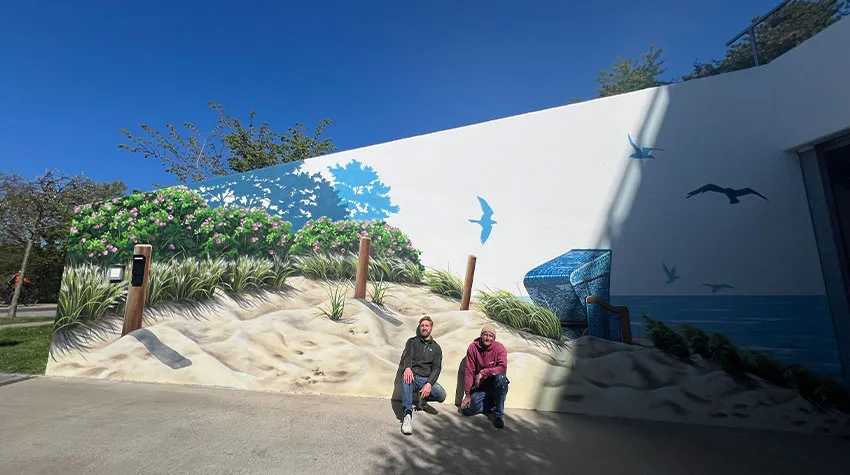 Siering und Hendrik Uterwedde von ART-EFX aus Potsdam posieren vor ihrem Graffiti-Kunstwerk in Ahrenshoop. 