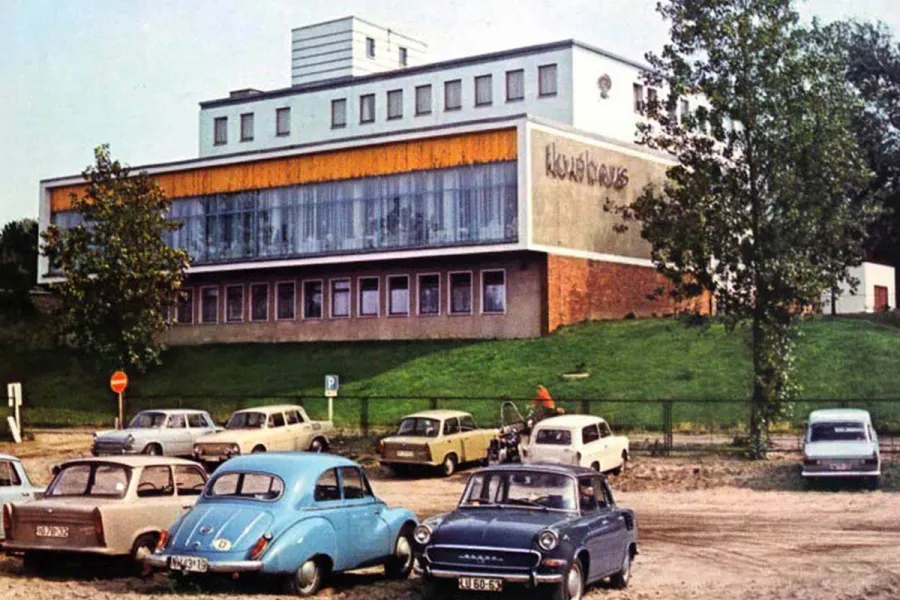 Historische Aufnahme des Kurhauses Ahrenshoop mit parkenden Autos aus früheren Jahrzehnten.