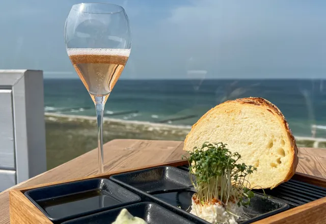 Ein saftiges Sauerteigbrot an der Ostsee mit einem Glas Rosé Wein.