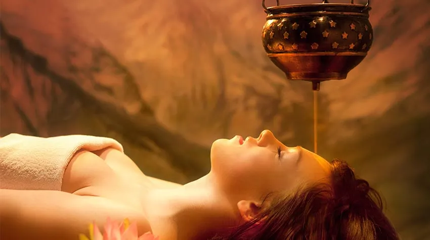 Die ayurvedische Therapie Shirodhara führt zu einem Gesichtsölguss, der das Stirnchakra stimuliert. © Adobe Stock, AlexanderNovikov
