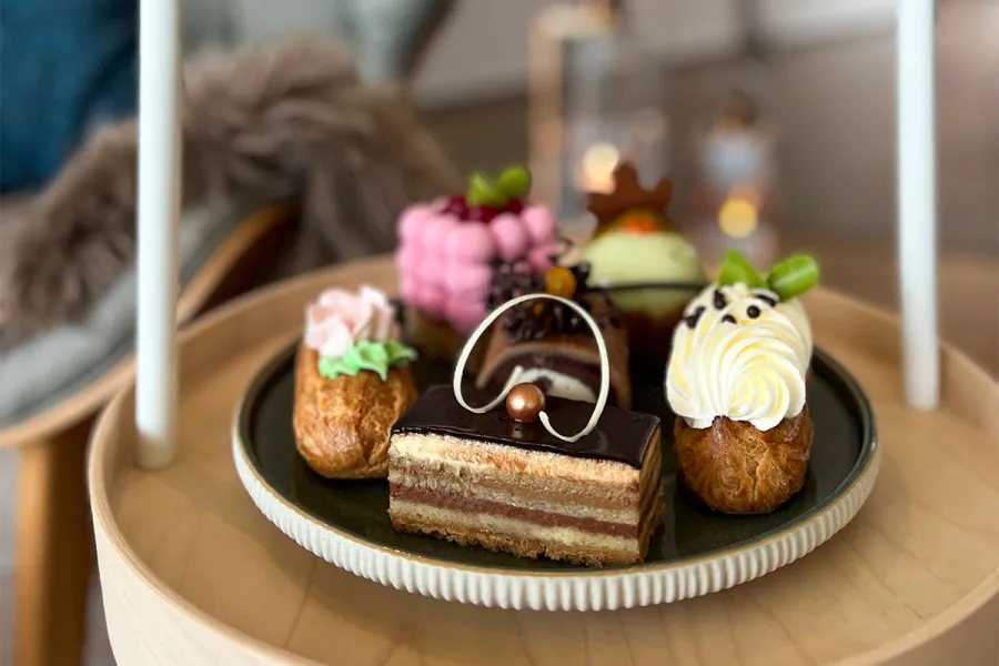 Verschiedene Törtchen und Eclairs stehen auf einer Etagere in Ahrenshoop.