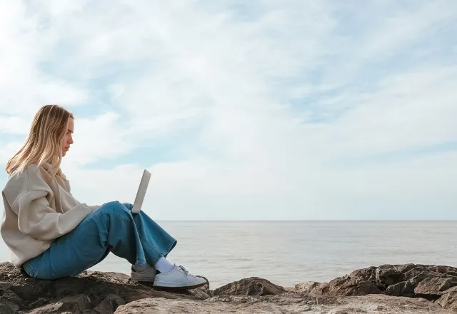 Frau die Workation an der Ostsee macht und am Laptop arbeitet. ©Adobe Stock, shintartanya