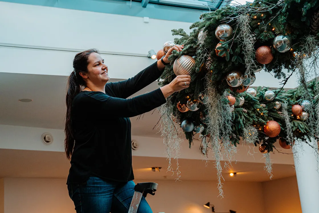 Hausdame und Floristin Carolin hat den Kranz gebunden und gibt dem Adventskranz in luftiger Höhe noch den letzten Feinschliff. © Max Framke