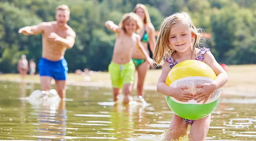 Familie mit Strandball im Wasser