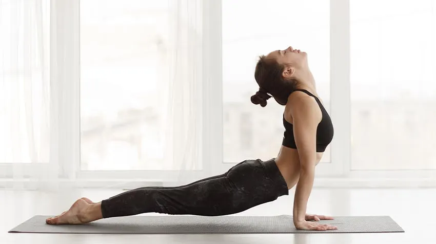 Die Ausführung der Asana erinnert an eine Schlange, die ihren Kopf nach oben reckt. Sie erhöht die Flexibilität der Wirbelsäule und weitet den Brustkorb.© Shutterstock, Prostock-studio
