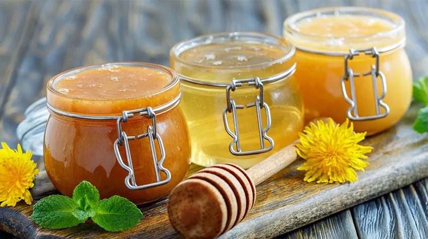 Drei Gläser mit verschiedenen Honigsorten. Eine dunkel und cremig, eine hell und klar, eine hell und cremig. Honig entsteht in vielen Sorten, je nachdem, wo die Bienen ihren Nektar herholen. ©Adobe Stock, sriba3