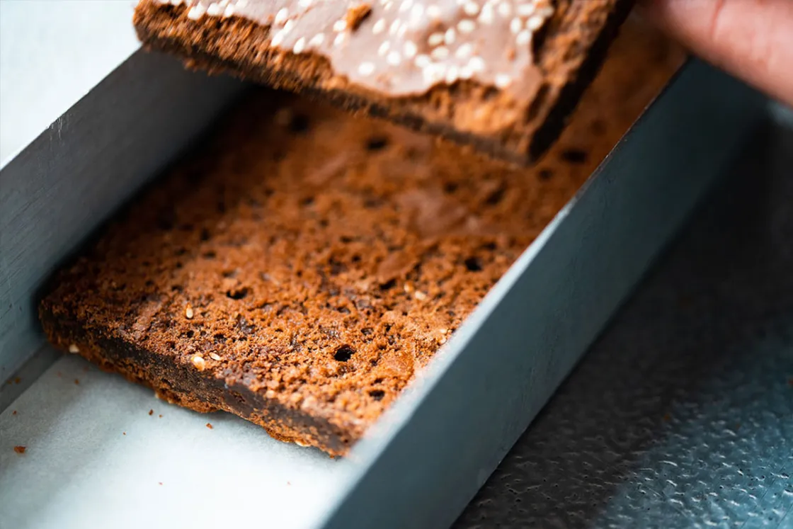 Lass die Brownies einige Zeit in der Backform auskühlen und schneide sie dann in die gewünschte Portionsgröße zu.