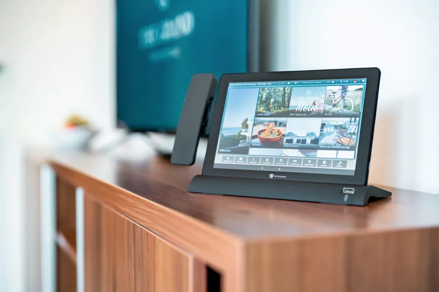 Digitales Infotablet auf einem Sideboard im Zimmer des THE GRAND Ahrenshoop.