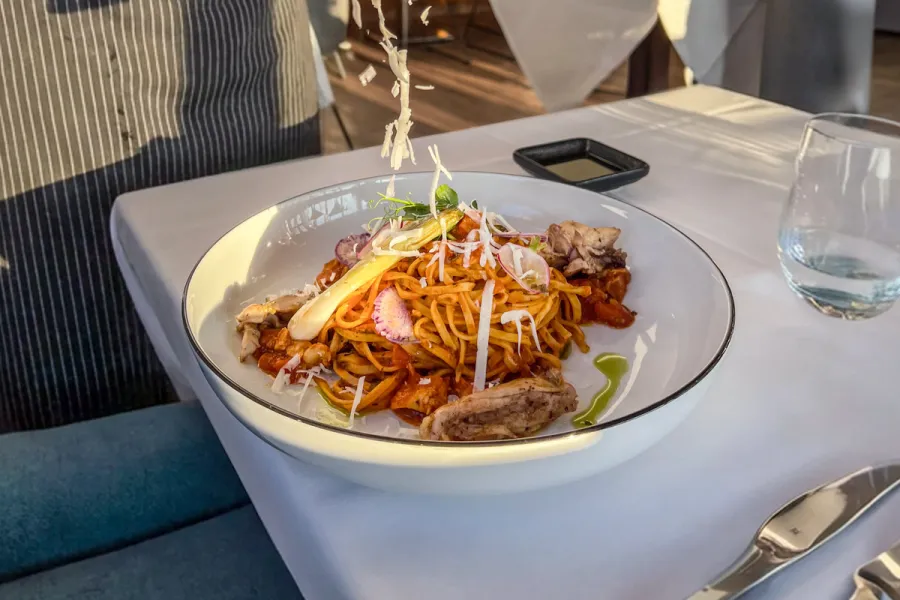 Frisch zubereitetes Pastagericht mit gehobeltem Käse und saisonalen Zutaten im WEITBLICK Restaurant des THE GRAND Ahrenshoop