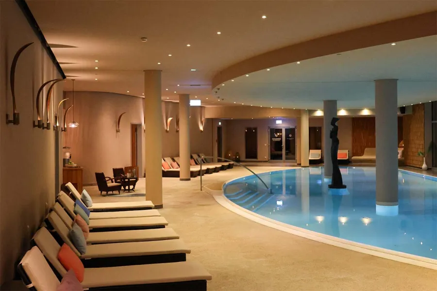 Innenpool mit Liegen im Spa Bereich des THE GRAND Ahrenshoop an der Ostsee.