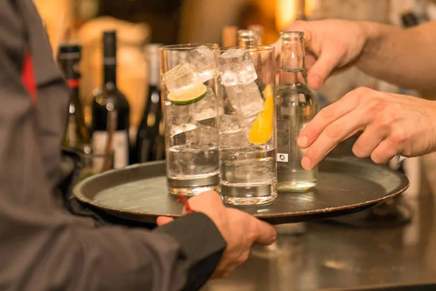 Chef de Rang (m/w/d) serviert Getränke im THE GRAND Ahrenshoop während des Gästeservices.