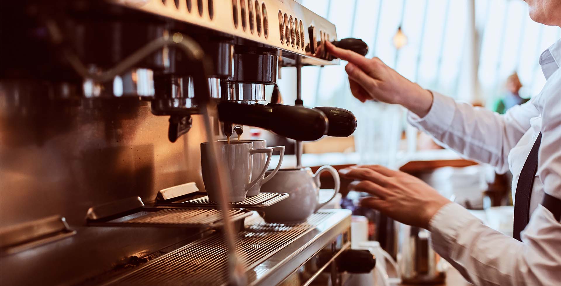 Servicekraft bedient professionelle Kaffeemaschine im THE GRAND Ahrenshoop.