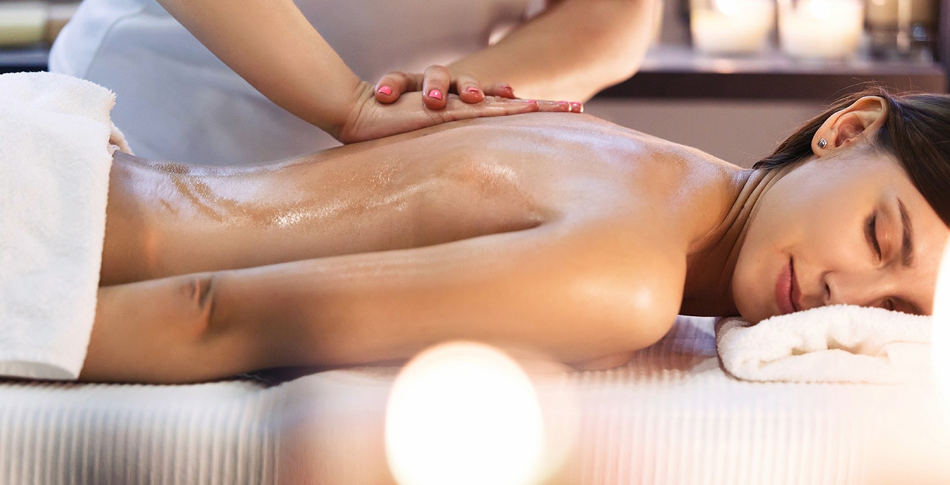 Eine Frau genießt eine professionelle Rückenmassage mit Öl in einem ruhigen Wellnessbereich und vermittelt die Tätigkeit eines Wellness-Therapeuten.
