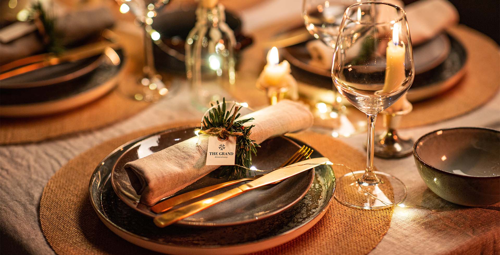 Festlich gedeckter Esstisch mit Kerzen und weihnachtlicher Atmosphäre im SEASIDE Restaurant des THE GRAND Ahrenshoop