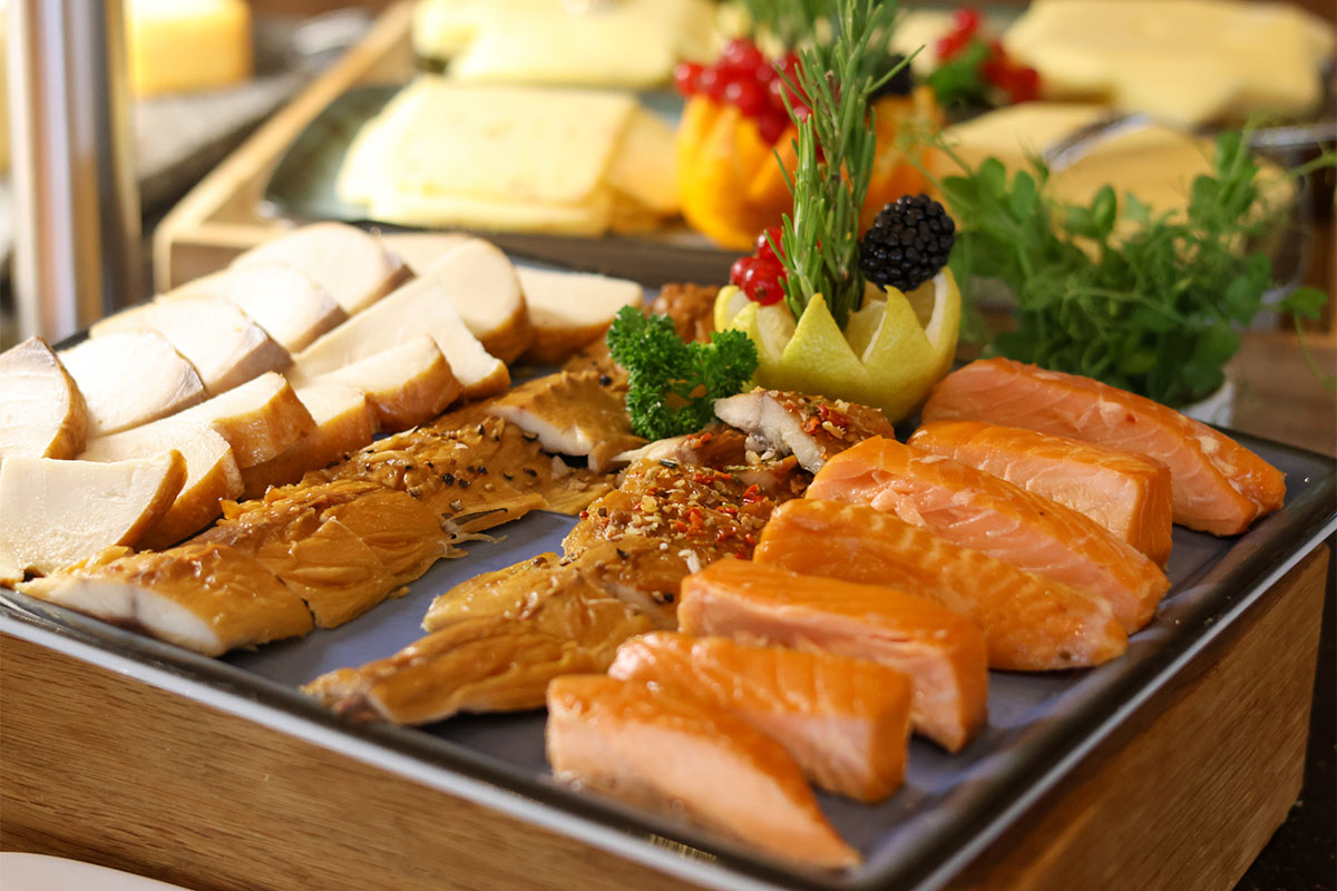 Frühstücksauswahl im THE GRAND Ahrenshoop mit Lachs, Käse und frischen Beilagen.