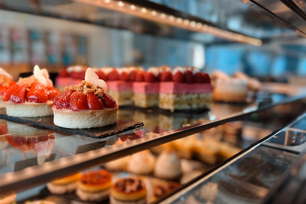 Auswahl an Törtchen und Desserts in der Vitrine der THE GRAND Patisserie.