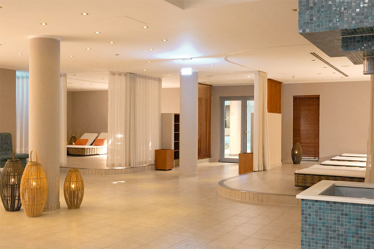 Ruhebereich im Spa des THE GRAND Ahrenshoop mit Liegen, Vorhängen und warmem Licht.